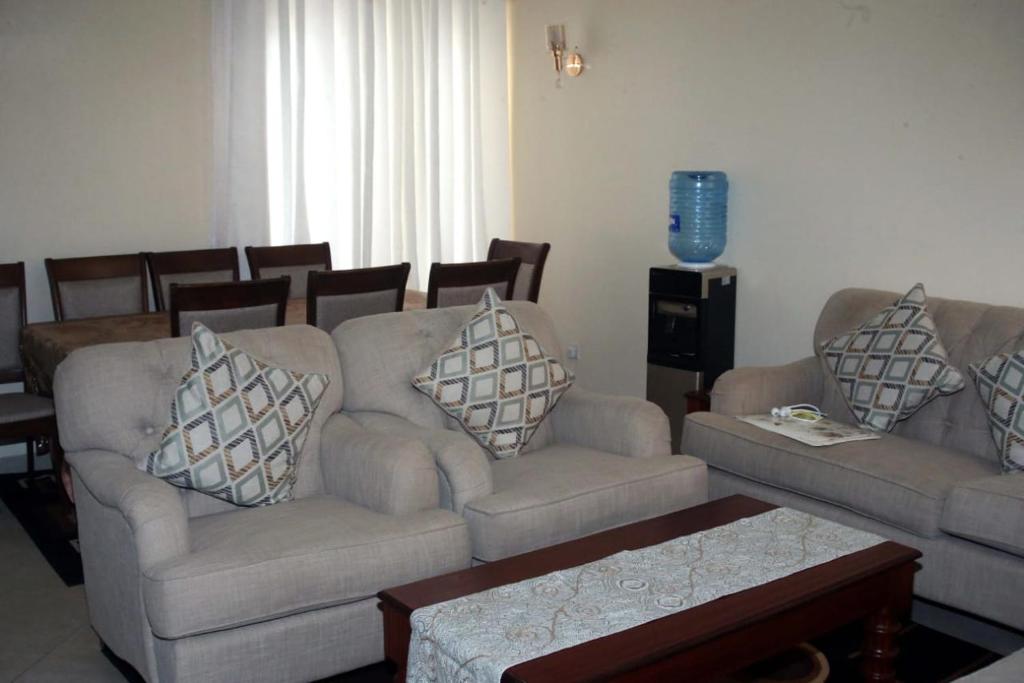 ein Wohnzimmer mit 2 Sofas und einem Tisch in der Unterkunft COSY HOMES SOUTHB in Nairobi