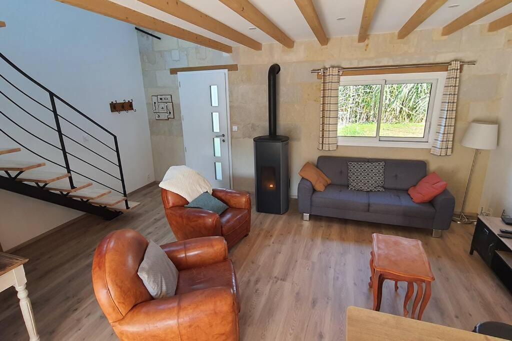 sala de estar con muebles de cuero y chimenea en Gîte Sweetloire, en La Menitré