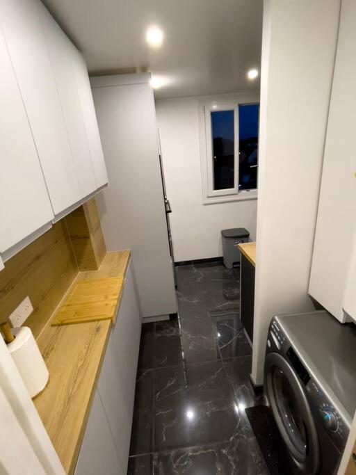 a small kitchen with a washing machine in it at Magnifique appartement de 4 chambres 8 personnes max à 20 minutes de Paris in Antony