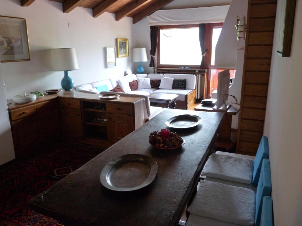 a living room with a table with plates on it at Mansarda in chalet a Cortina in Cortina dʼAmpezzo