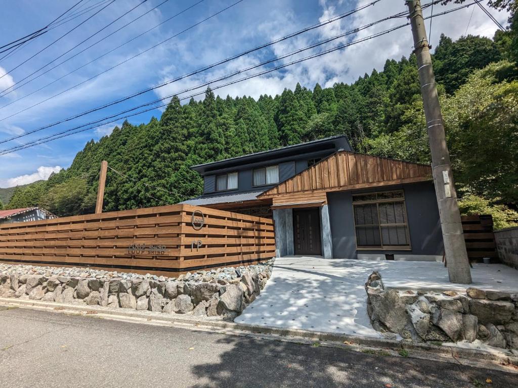 a house with a wooden fence in the mountains at LOOP-shiso in Shiso