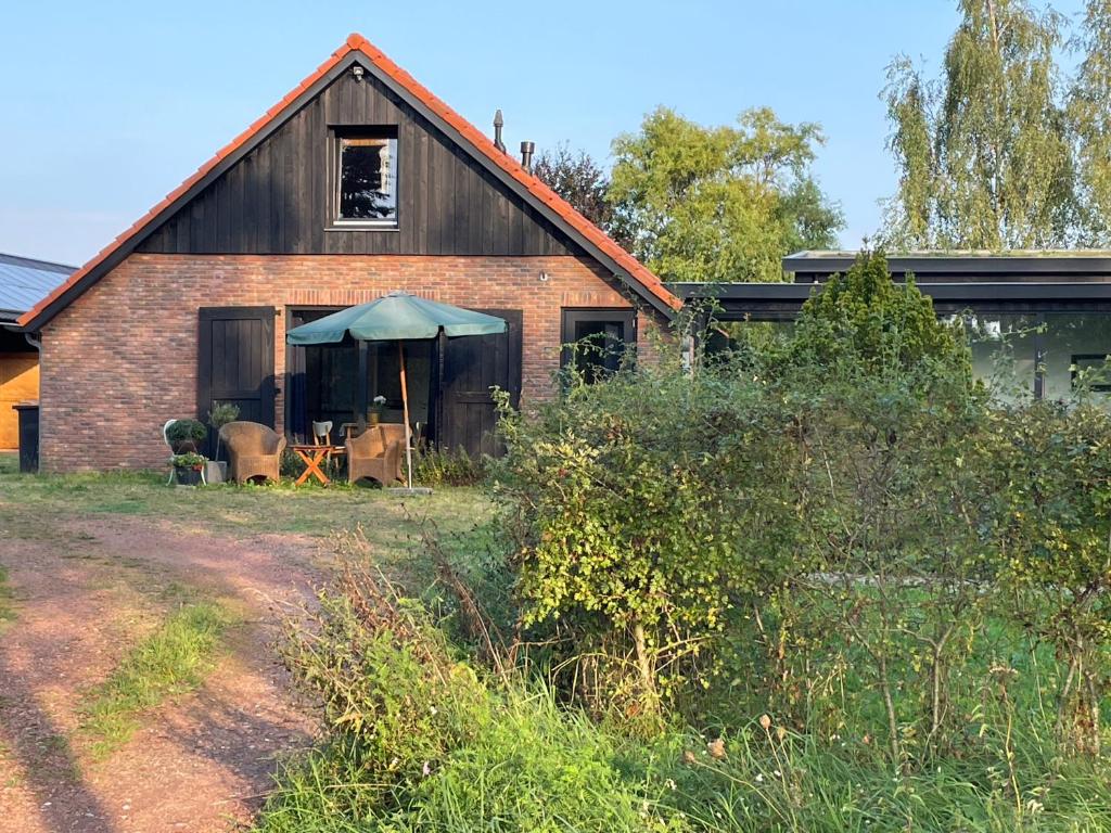 een schuur met een tafel en stoelen ervoor bij vakantieverblijf Marke Lemselo in Weerselo