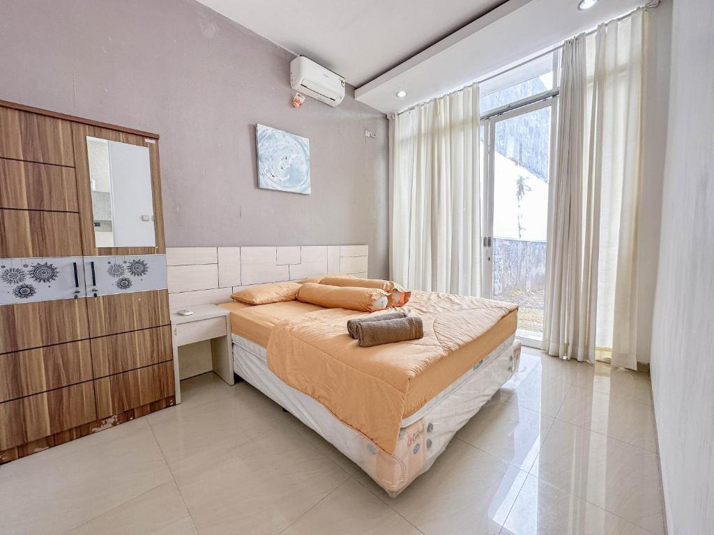- une chambre avec un grand lit et une grande fenêtre dans l'établissement Villa Kalimaya - 3 Bedrooms, à Dau