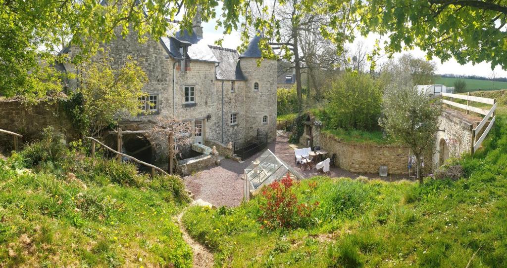 an old stone house on a grassy hill at Moulin de la Bretonnière - Omaha Beach Dday in Aignerville