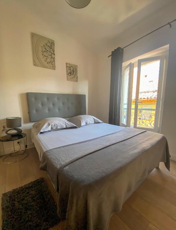 a bedroom with a large bed and a window at Appartement Biot Village in Biot