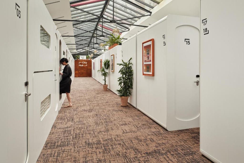 a woman walking down a hallway in a building at CityHub Amsterdam in Amsterdam