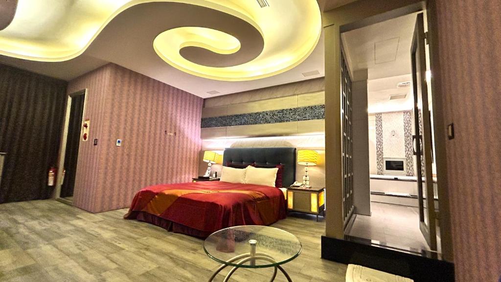 um quarto de hotel com uma cama e uma mesa de vidro em Shining Motel em Taichung