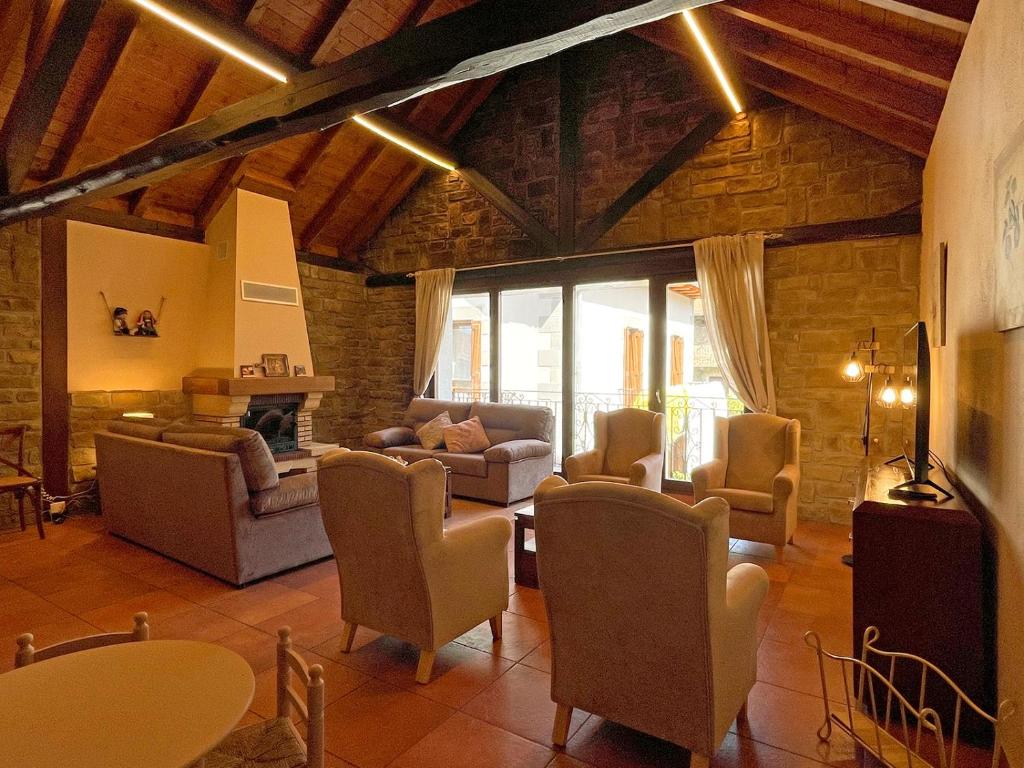 sala de estar con sofás, sillas y chimenea en Casa Rural juaningratxi, en Isaba