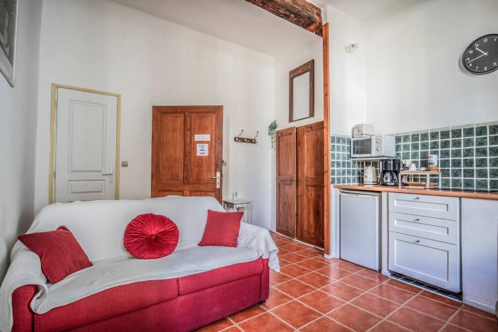 - une chambre avec un canapé rouge dans une cuisine dans l'établissement Appartement 2ème étage plein cœur centre historique de Pézenas, à Pézenas