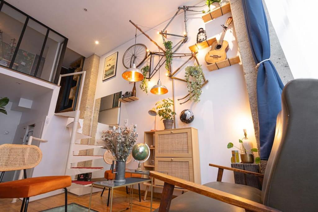 un salon avec un escalier et quelques plantes sur le mur dans l'établissement Unique MontmartreSacré-Cœur appartement Parking, à Paris