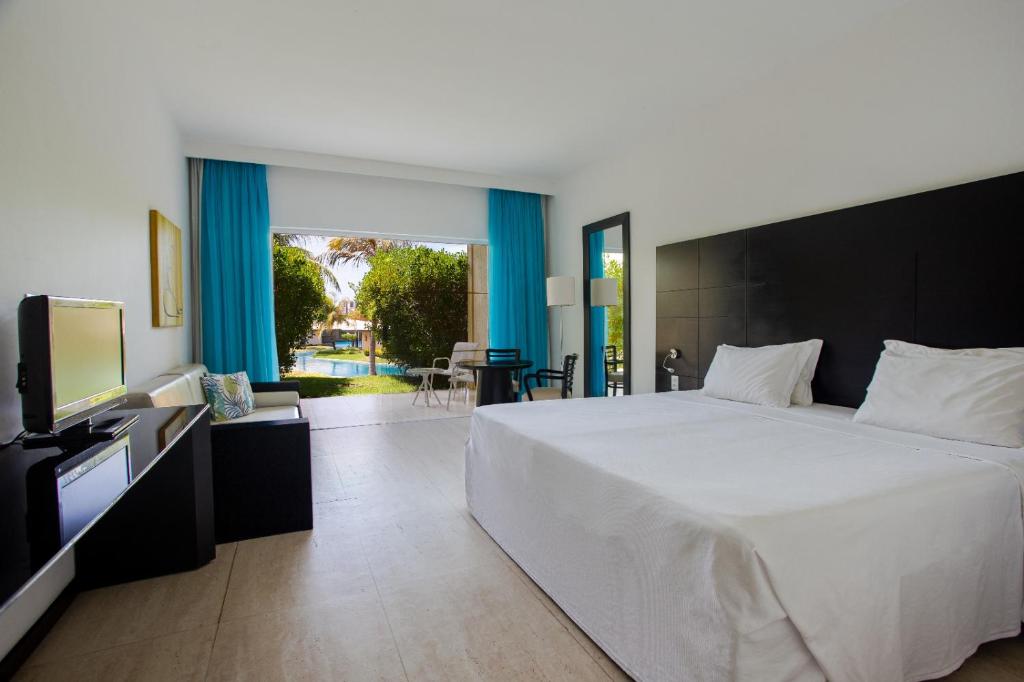 1 dormitorio con 1 cama grande y TV en HOTEL DOM PEDRO LAGUNA en Aquiraz