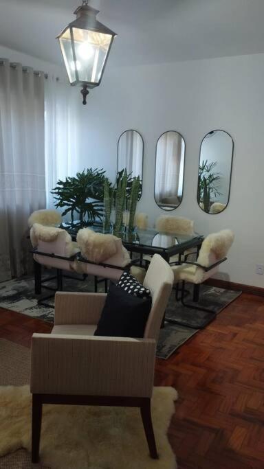 a living room with a couch and a table and mirrors at Aconchegante apt c/ garagem in Serra Negra