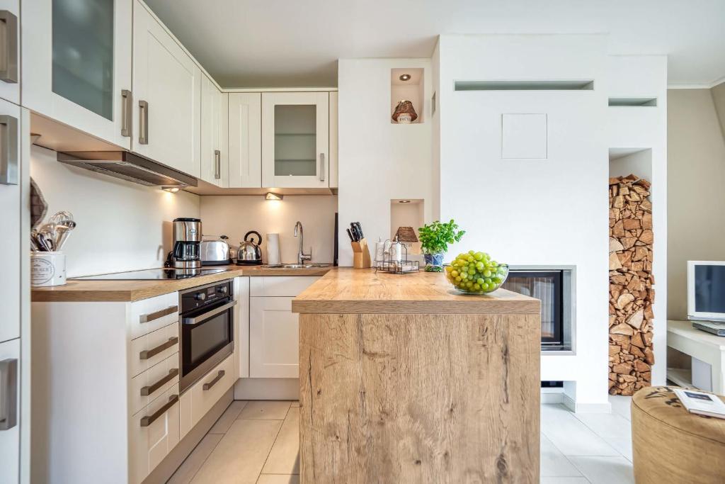 una cocina con armarios blancos y una isla de madera en Strandappartement Wieck Nr 4, en Zingst