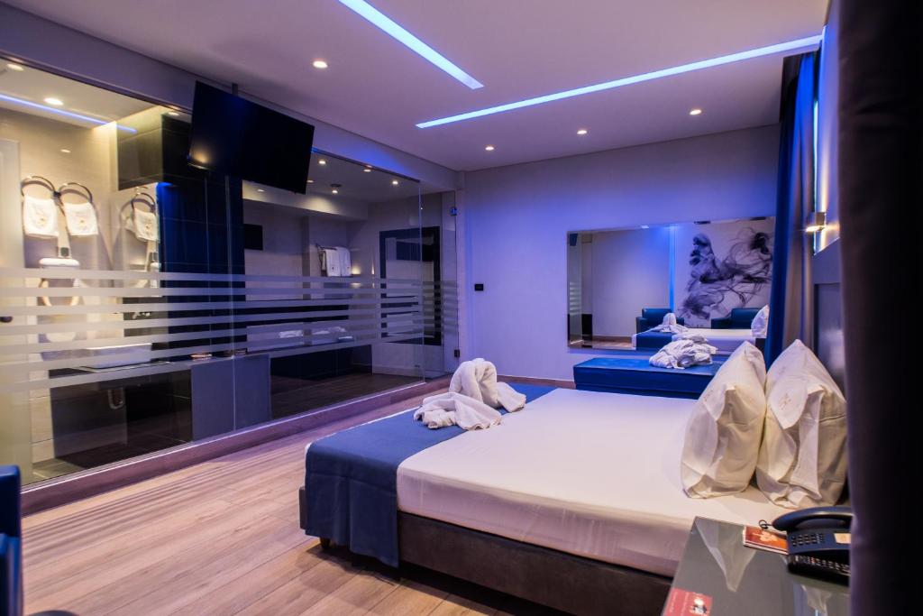 sypialnia z łóżkiem i telewizorem w pokoju w obiekcie Pines Hotel w Atenach