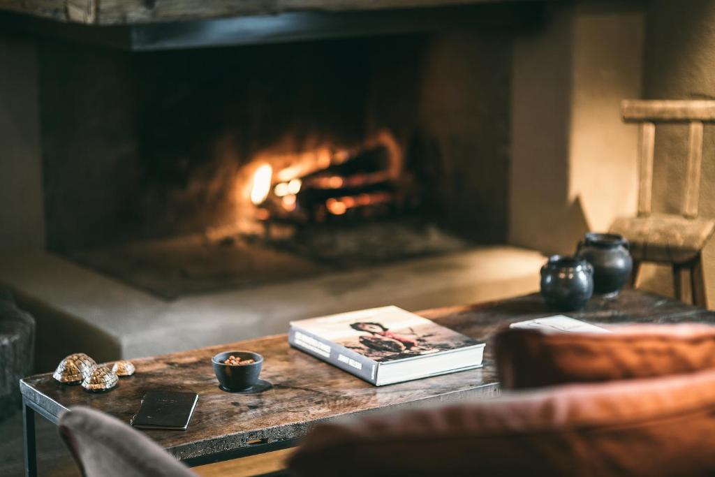 a book on a table in front of a fireplace at Zannier Hotels Le Chalet in Megève