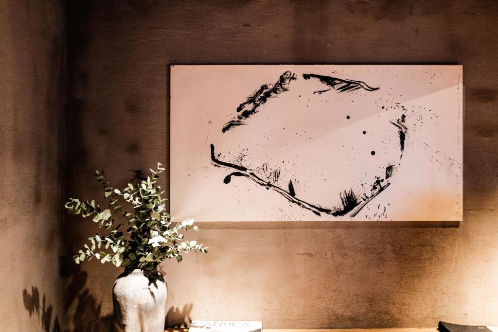 a drawing of a heart on a wall with a vase with flowers at Zannier Hotels Le Chalet in Megève