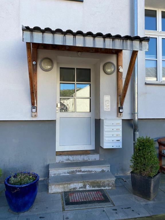 una puerta de entrada de una casa con una olla azul en Große Post, en Schleiden