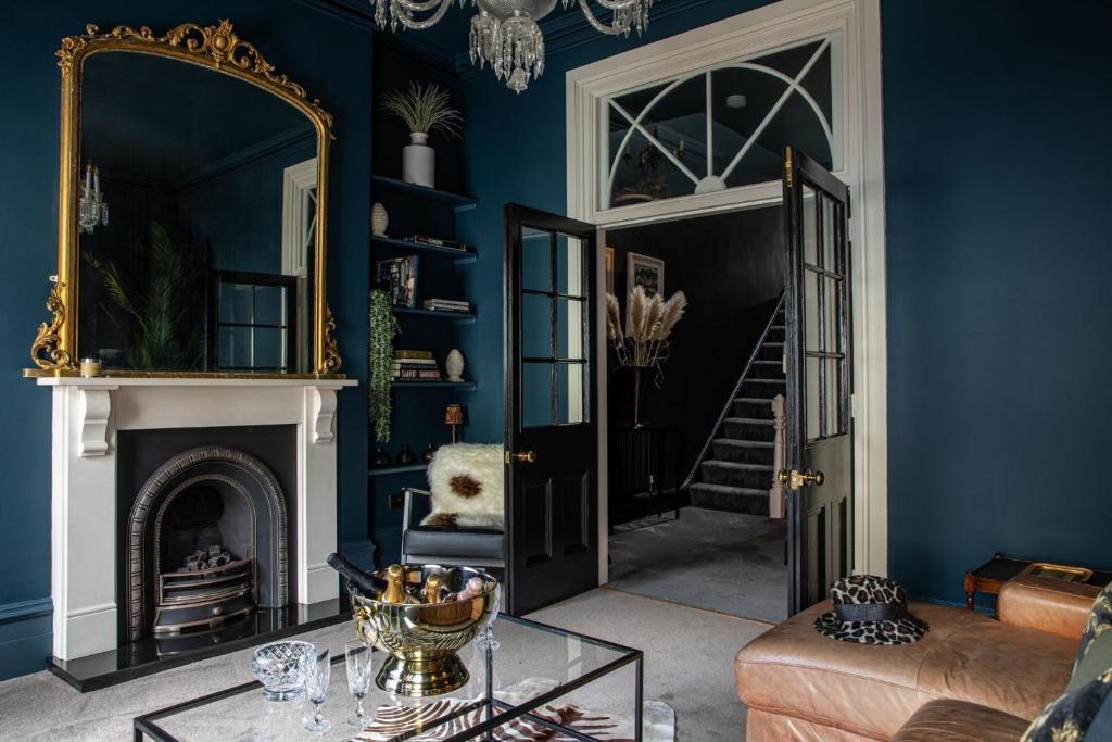 謝伯恩的住宿－The Townhouse Sherborne，客厅设有蓝色的墙壁和镜子
