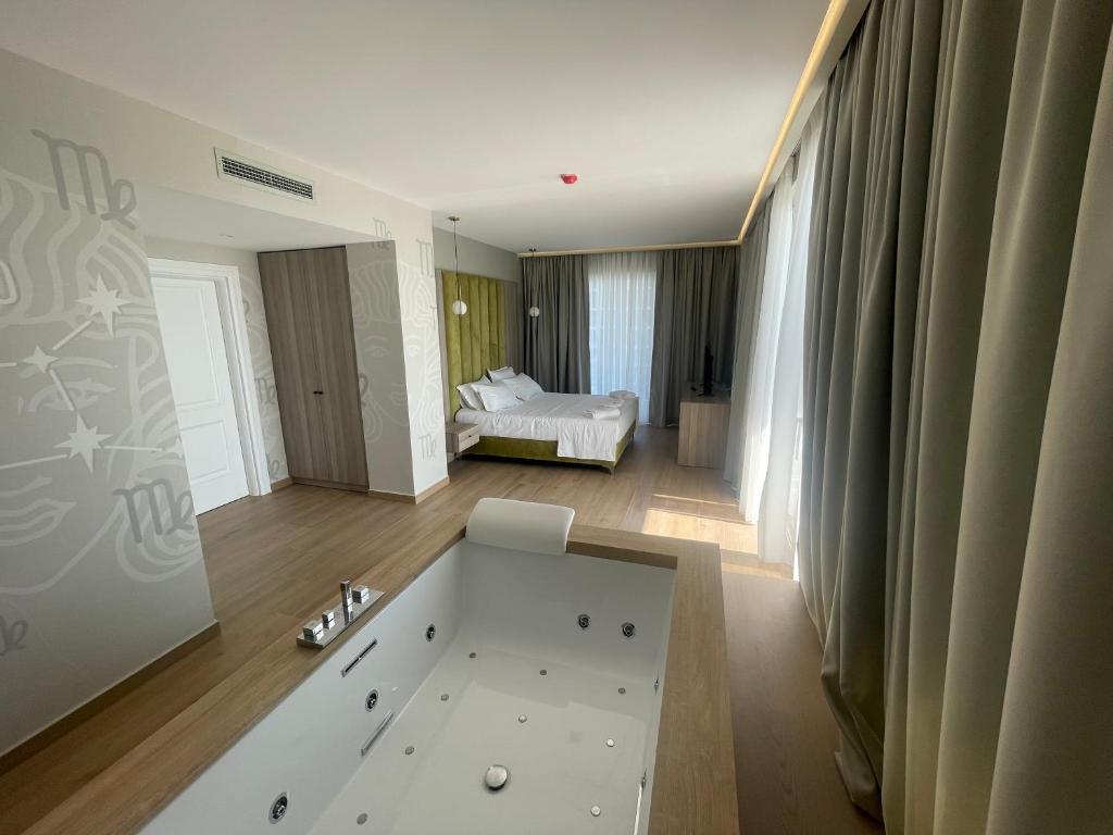 a bathroom with a bath tub and a bedroom at SACA HOTEL in Shëngjin