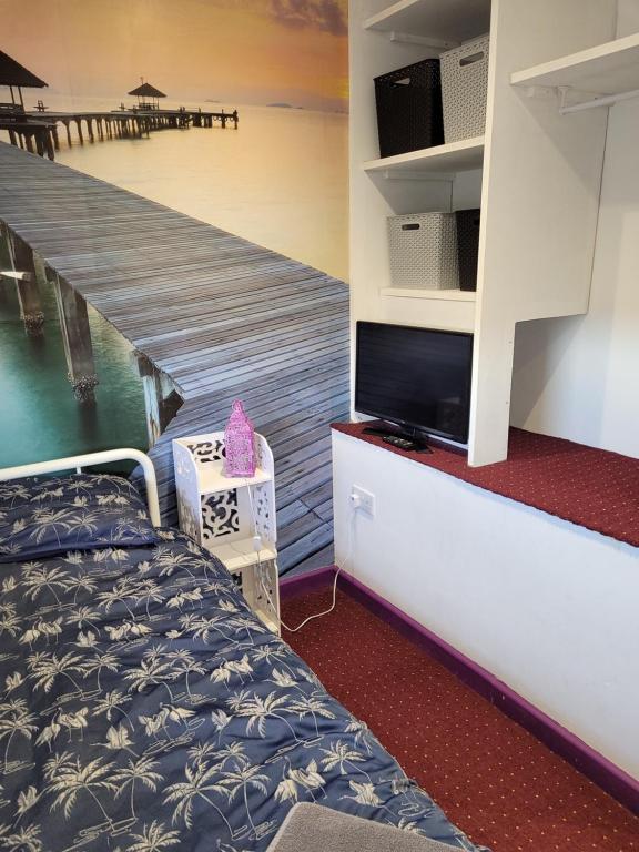 a bedroom with a bed and a television and a dock at No 3 Lingdale - 4 bedroom house close to N Yorks Moors in Boosbeck