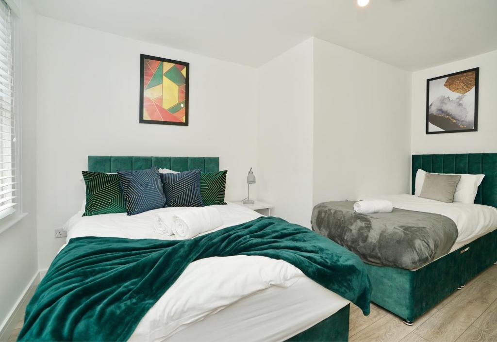 2 letti in una camera da letto con verde e bianco di Huntingdon Luxury Apartments a Huntingdon