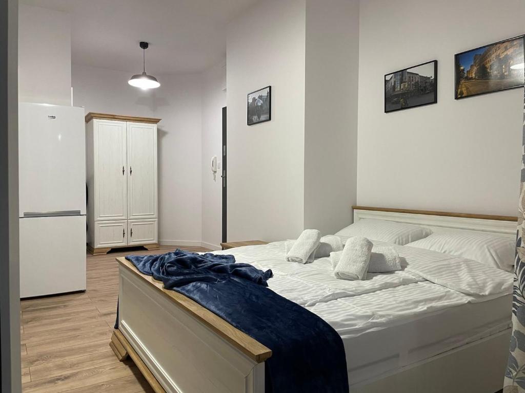 a bedroom with a bed and a refrigerator at Apartament Łodzianina in Łódź