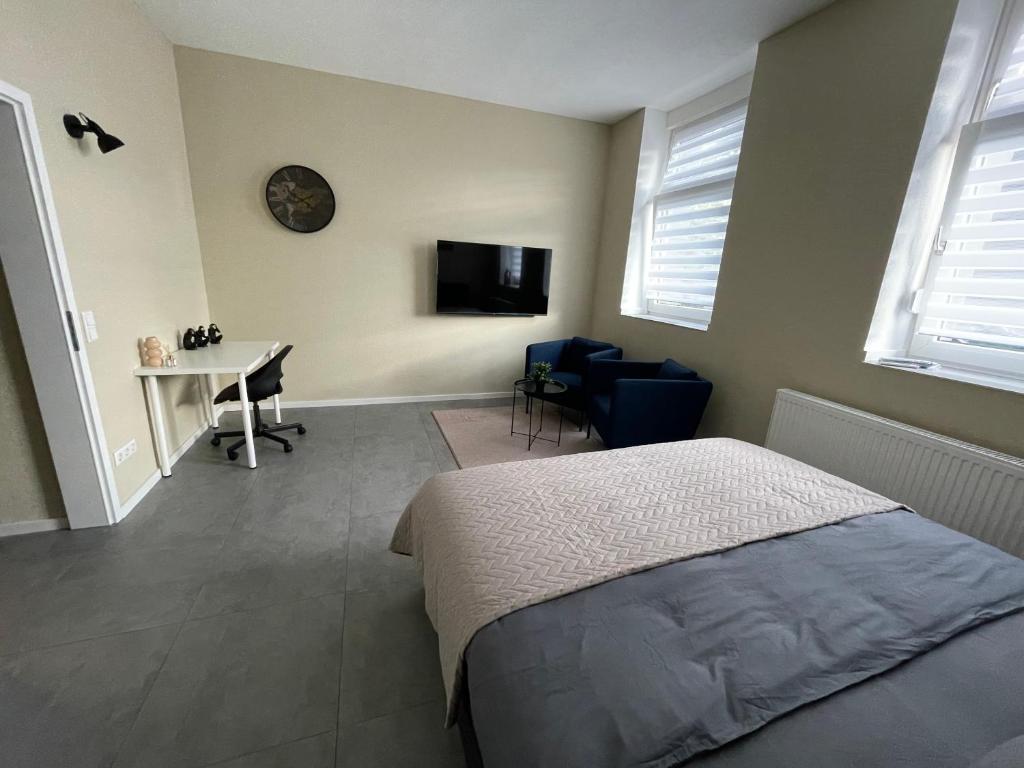 a bedroom with a bed and a desk and a tv at Europa Apartments nähe Düsseldorf Messe, Airport in Krefeld