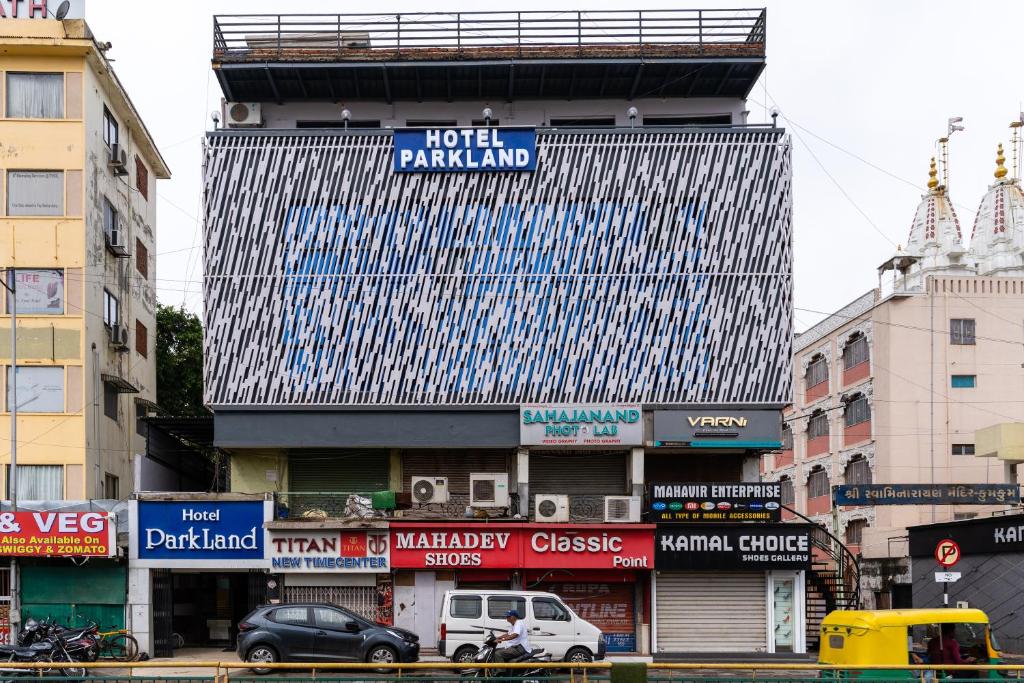 a tall building with a lot of signs on it at Hotel Parkland Manage by G Express in Ahmedabad