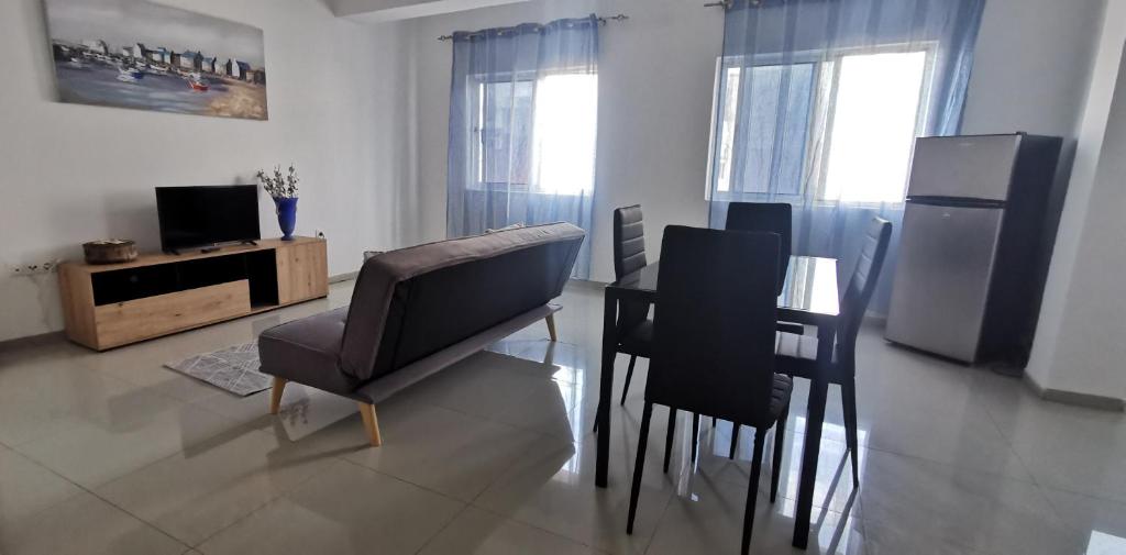 un soggiorno con sedie, tavolo e TV di Apt Plateau a Praia