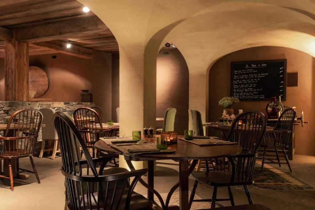 a restaurant with tables and chairs and a menu on the wall at Zannier Hotels Le Chalet in Megève
