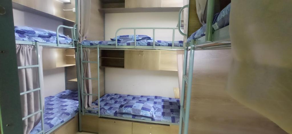 a room with three bunk beds in a room at Smart Hostel in Dhaka