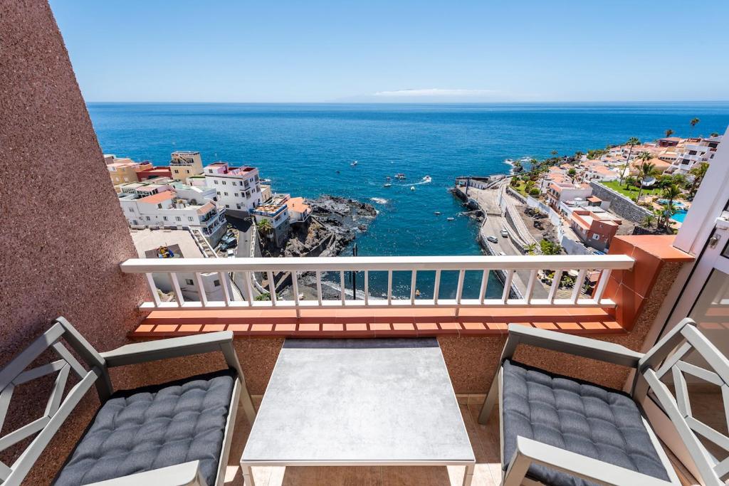a balcony with two chairs and a view of the ocean at Bahia cozy ocean view suite in Puerto de Santiago