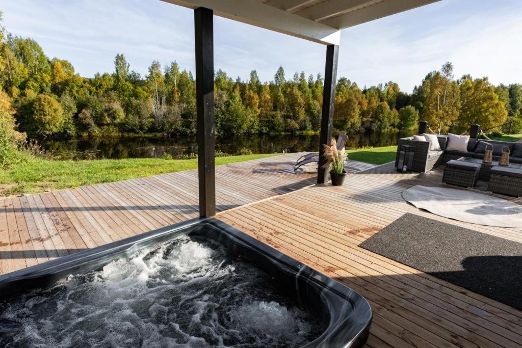 una bañera de hidromasaje en una terraza junto a un cuerpo de agua en Villa Mommo II, en Rovaniemi