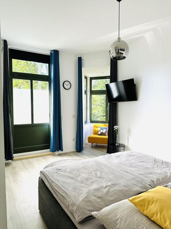 a bedroom with a bed and a window with blue curtains at City Center Leipzig II in Leipzig