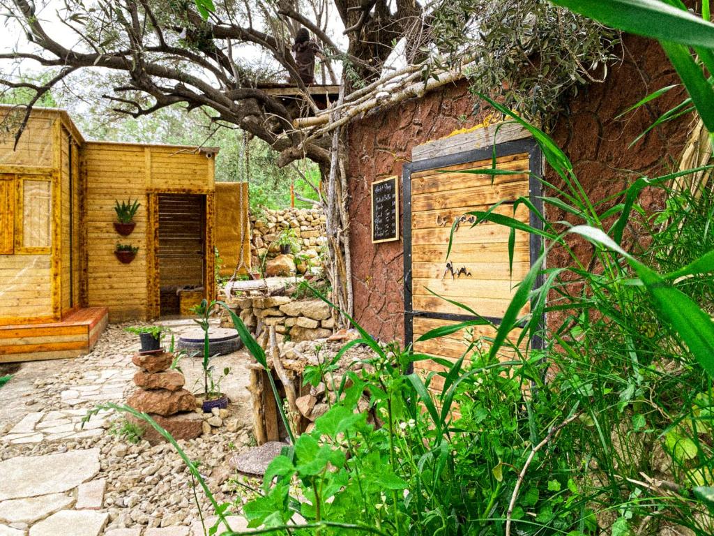 達納的住宿－Hobbit village，花园中带门的小石头建筑