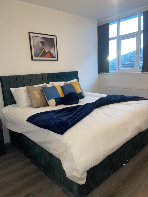 1 dormitorio con 1 cama grande con almohadas en Flitwick Luxury 3 Bedroom Apartment, en Flitwick
