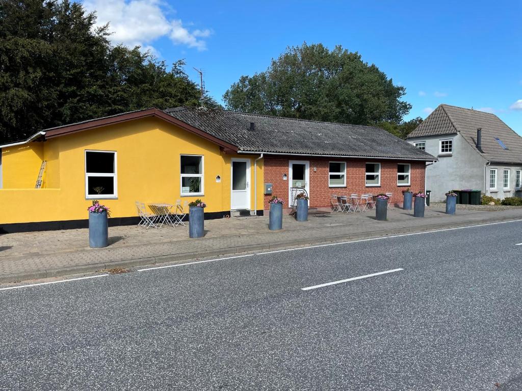 un bâtiment jaune et rouge sur le côté d'une rue dans l'établissement Stay in Brøns, à Skærbæk