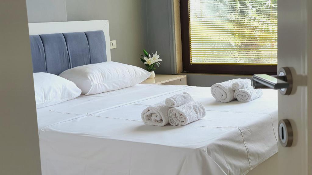 1 dormitorio con 1 cama con toallas enrolladas en Jessie's apartments, en Durrës