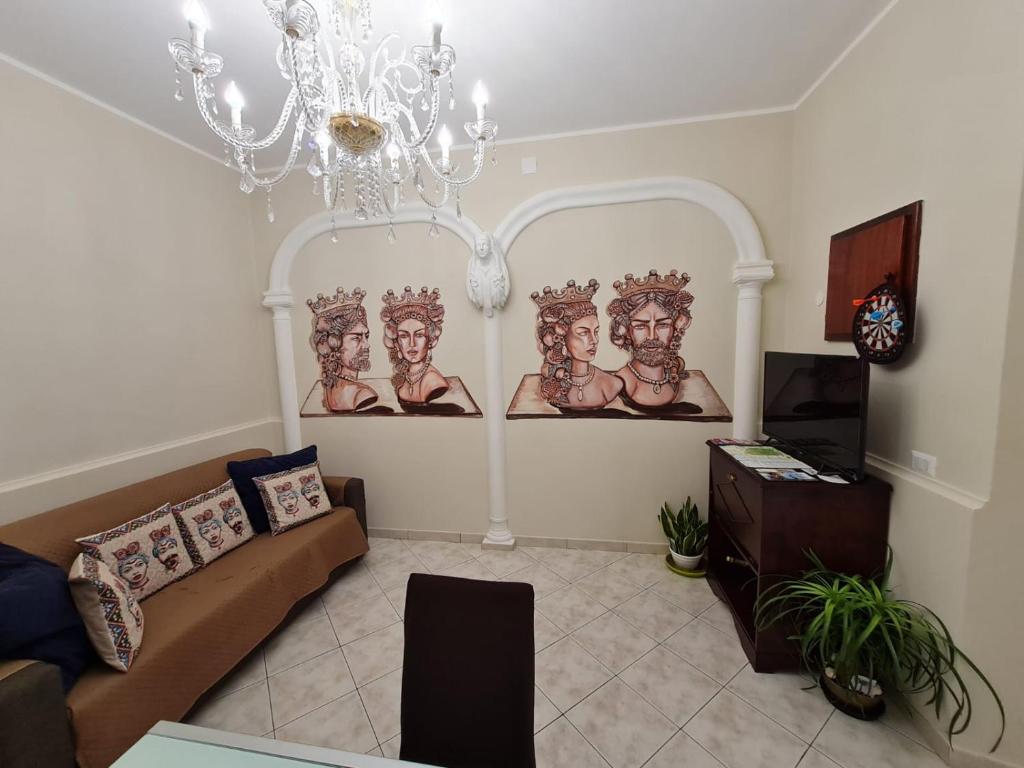 una sala de estar con una lámpara de araña y pinturas en la pared en Sicilia Mount&Sea, en Mascali