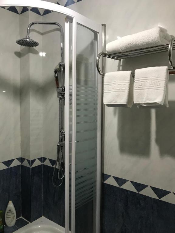 een badkamer met een douche en een wastafel met handdoeken bij Simbiose in Carcavelos