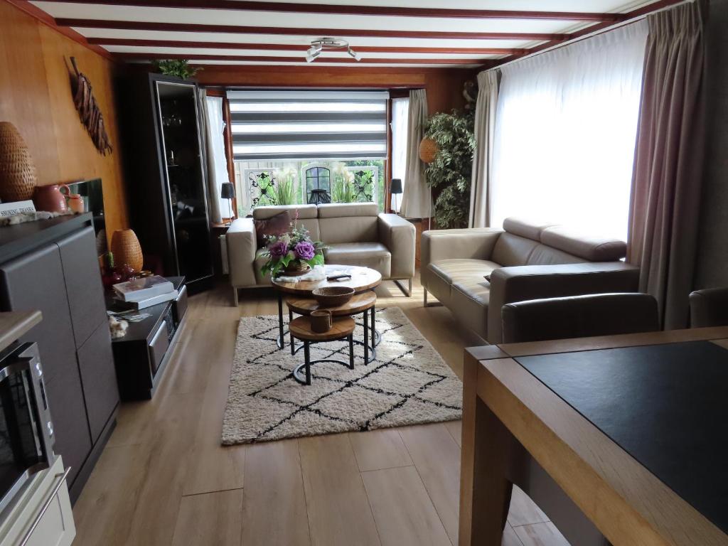 a living room with a couch and a table at Veluwe Park Reewold Chalet Vision in Putten
