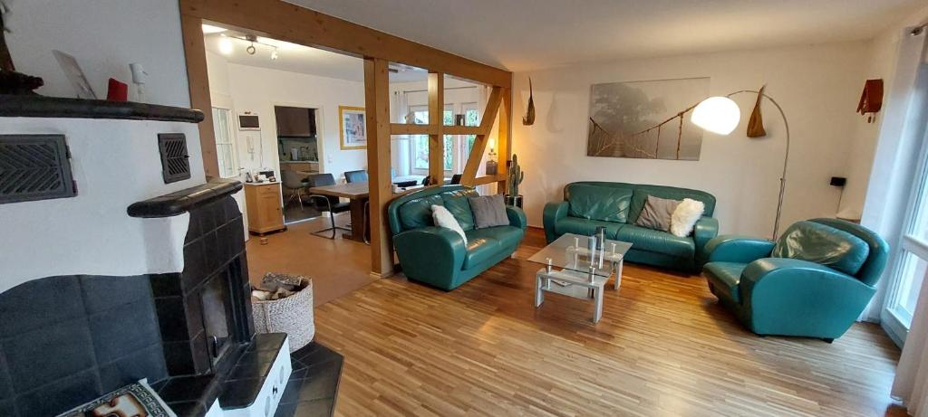 sala de estar con 2 sofás verdes y chimenea en Haus auf der Schwäbischen Alb, en Grabenstetten