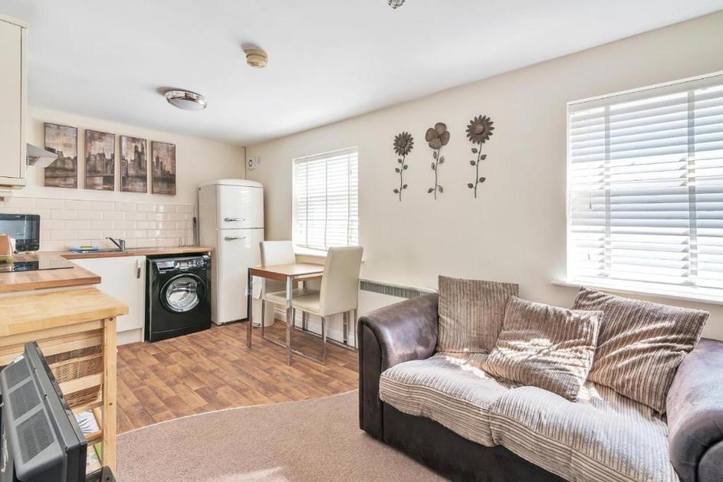 a living room with a couch and a kitchen at Coach House - Lovely 1 Bedroom Flat near Derby City Centre in Derby