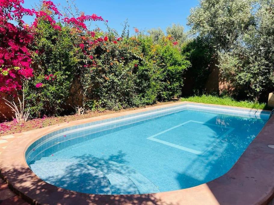 einen Pool in einem Garten mit Blumen in der Unterkunft Villa Korima in Marrakesch