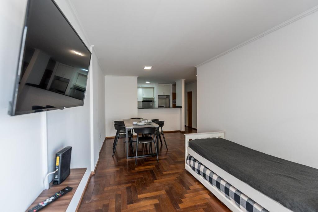 1 dormitorio con 1 cama y comedor con mesa en cómodo departamento para 6 personas en Córdoba