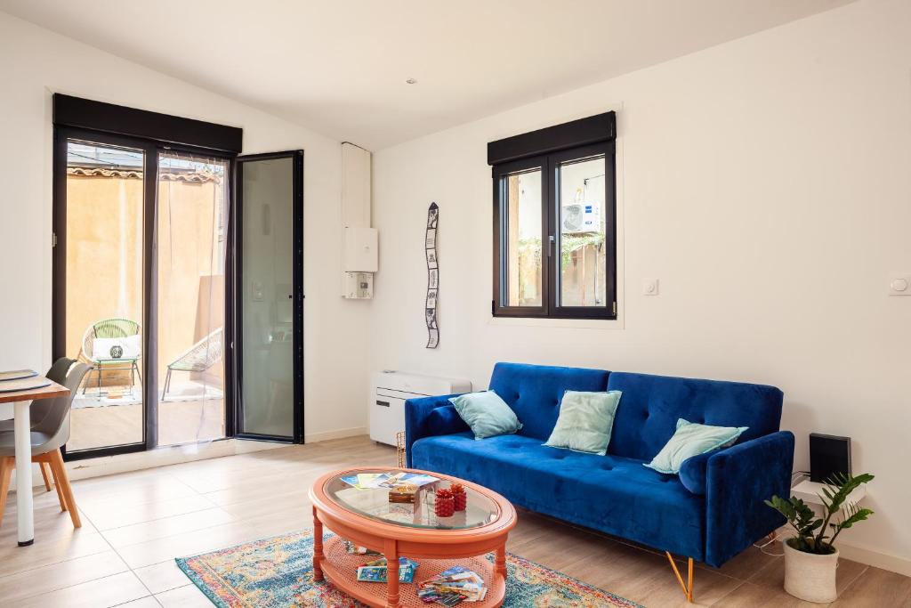 uma sala de estar com um sofá azul e uma mesa em Villa Tania em Allauch