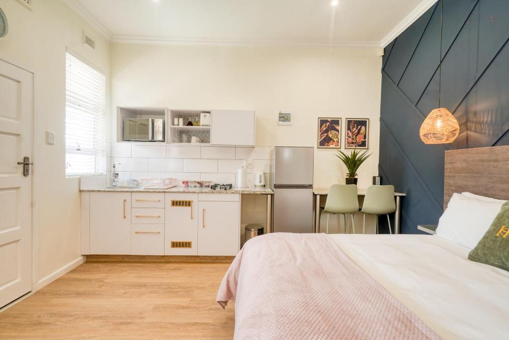 Il comprend une chambre avec un grand lit et une cuisine. dans l'établissement Hampton Collection - 2 Sleeper Studio Apartment with Pool, à Durban