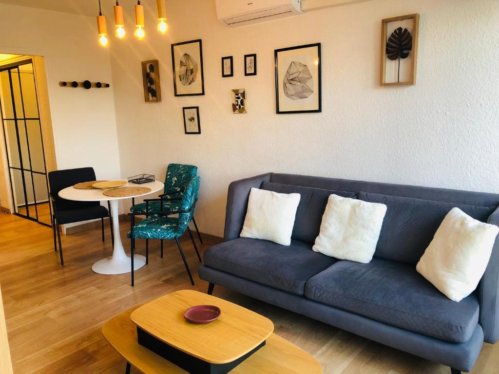 a living room with a blue couch and a table at Superbe appartement avec internet et parking gratuit in Avignon