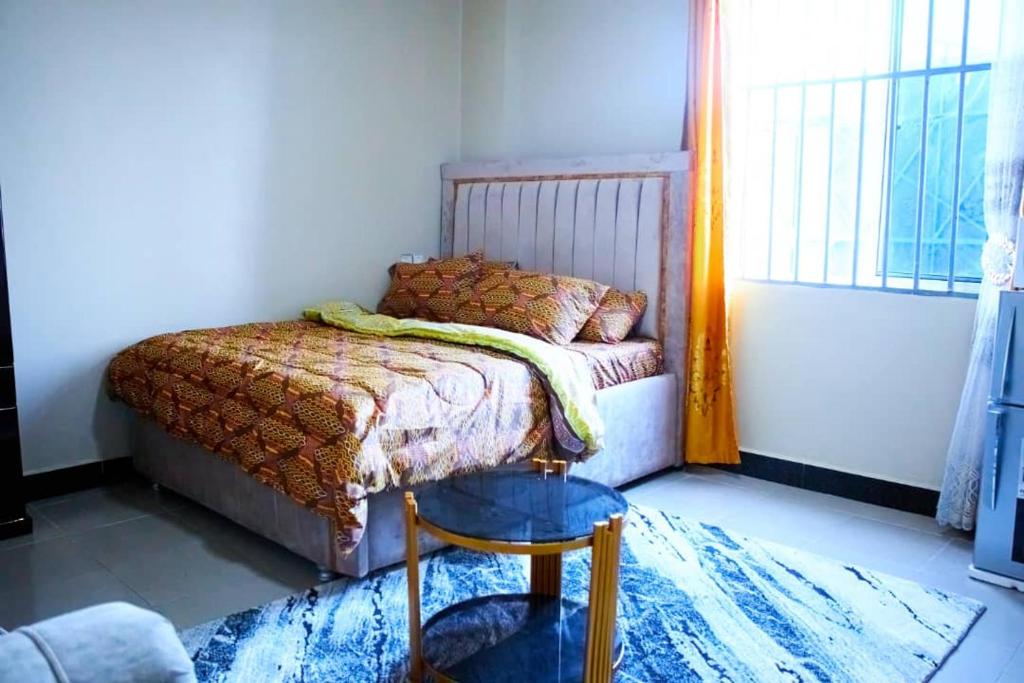 1 dormitorio con 1 cama en una habitación con ventana en Sojah Apartment, en Dar es Salaam