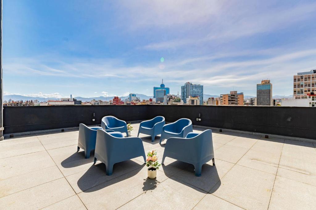 a group of blue chairs sitting on a roof at NEW La Roma Penthouse 100m2 Terrace Pool and Gym in Mexico City